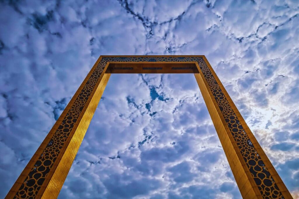 Take a picture of the gorgeous Dubai Frame with clouds.